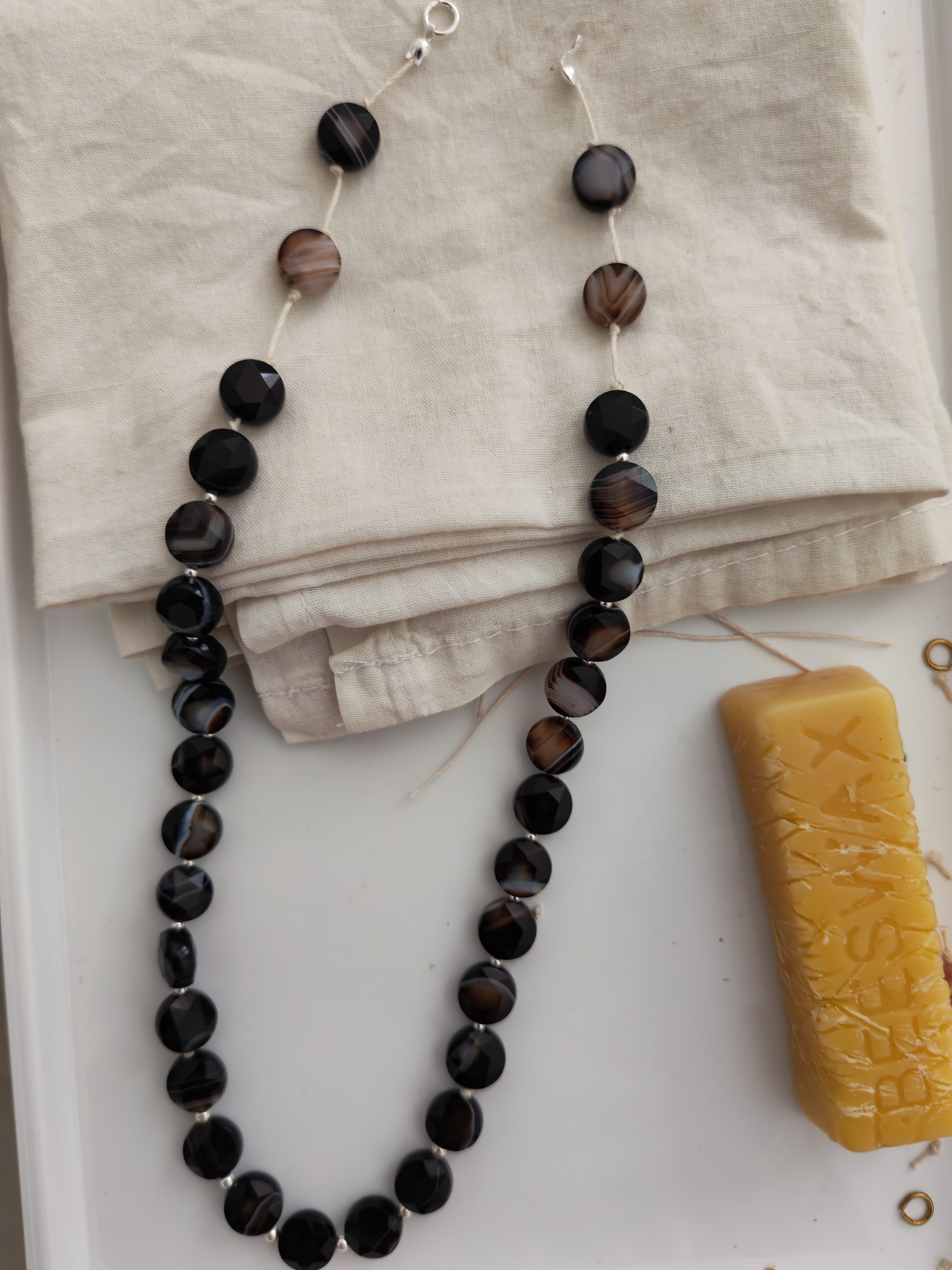 Black bead necklace on beige cloth